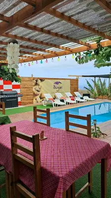 a table in front of a swimming pool with a tableablish at Bangaló Buzio Relax in Portal
