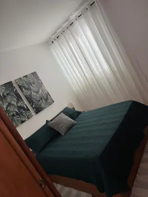 a bedroom with a green bed with a window at Apartamento Silva 1 in Praia