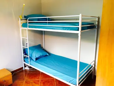 two bunk beds in a room with blue pillows at La Kaza du Soleil in Tarrafal