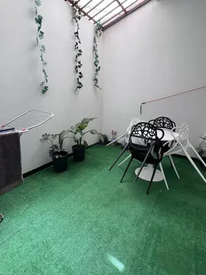 a room with a green floor with two chairs and plants at Appartement moderne au paradis in Santa Maria