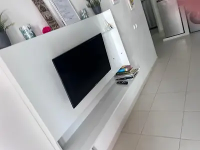 a tv on a white wall in a living room at Appartement moderne au paradis in Santa Maria