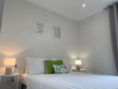 a white bedroom with a white bed with two lamps at Sal Little Heart Bia Apartment 19 in Santa Maria