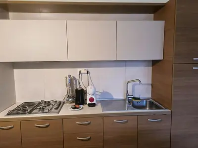 a kitchen with a sink and a stove and cabinets at Marialva Tropical T2 in Santa Maria