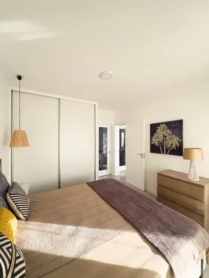 a bedroom with a large bed with white walls at Marina Mindelo Bay View in Mindelo