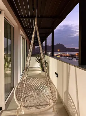 a swinging chair on a balcony with a view of the ocean at Marina Mindelo Bay View in Mindelo