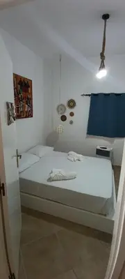 a white bedroom with a bed and a cross on the wall at Alma MIRIAM in Sal Rei