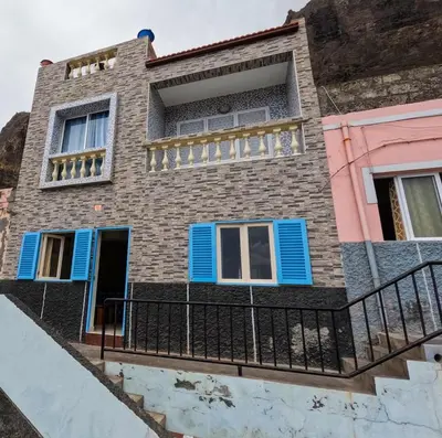 a house with blue shutters and a balcony at Kasa Amizade in Prainha