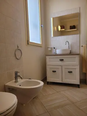 a bathroom with a sink and a toilet and a mirror at Lovely Seaview Apartment Magnolia in Santa Maria