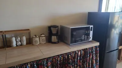 a microwave sitting on a counter next to a refrigerator at Lovely Seaview Apartment Magnolia in Santa Maria