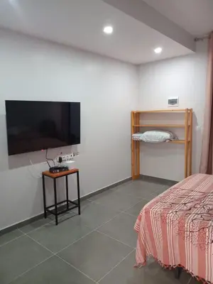 a bedroom with a bed and a flat screen tv at Abraço d Mindel in Mindelo