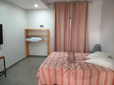 a bedroom with a bed with a pink comforter at Abraço d Mindel in Mindelo