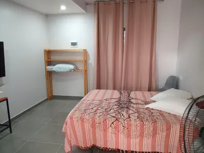 a bedroom with a bed with a pink comforter at Abraço d Mindel in Mindelo
