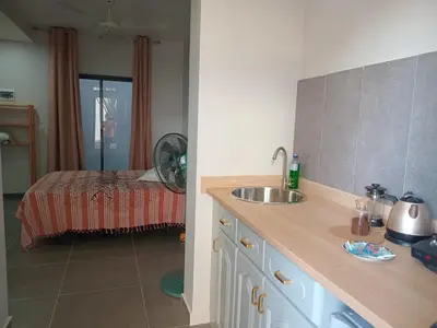 a kitchen with a sink and a bed in a room at Abraço d Mindel in Mindelo