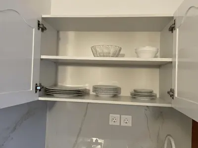 a white cabinet with plates and bowls on it at Apartament Salim in Beirona