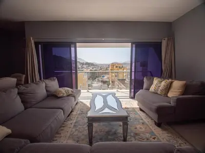 a living room with a couch and a table in front of a window at Apartamentos Octane Mindelo in Mindelo