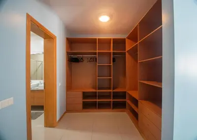 a walk in closet with wooden shelves and a mirror at Apartamentos Octane Mindelo in Mindelo
