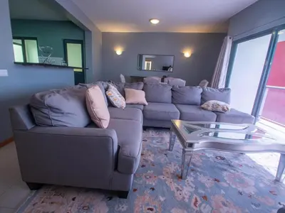 a living room with a couch and a glass table at Apartamentos Octane Mindelo in Mindelo