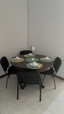 a table with chairs around it with a wine glass on it at Casa Fortes in Praia