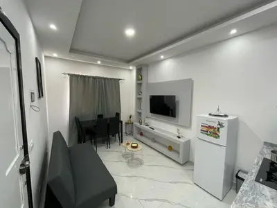a living room with a television and a dining room at Di Rosa Apartament in Praia