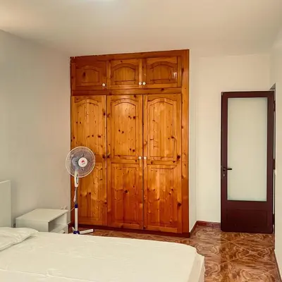 a bedroom with a wooden cabinet and a fan at Morabeza Serena in Santa Maria