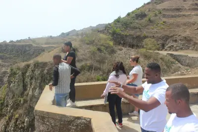 a group of people standing on a retaining wall at Hotel POUSADA Brava in Vila Nova Sintra