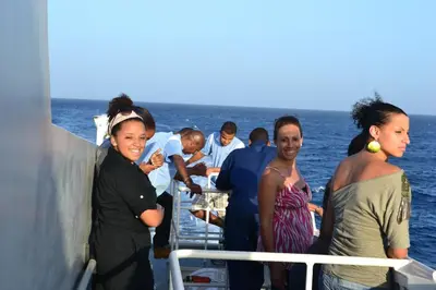 a group of people standing on a boat in the ocean at Hotel POUSADA Brava in Vila Nova Sintra