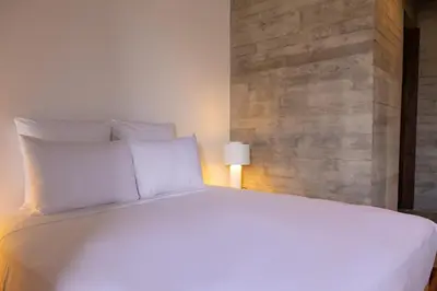 a bedroom with a large white bed with a lamp at Villa - Vue Mer et Piscine Privée in Mindelo