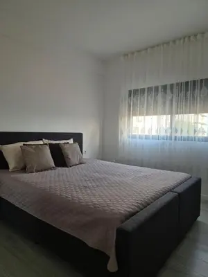 a bedroom with a large bed with a large window at Grace apartamento T2 in Praia