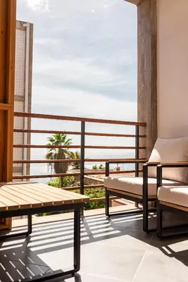 a balcony with a bench and a table and chairs at Bordão Apartments in Praia