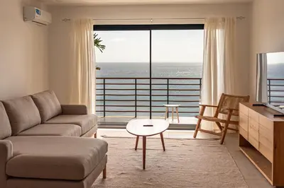 a living room with a couch and a view of the ocean at Bordão Apartments in Praia
