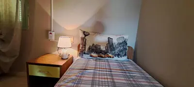 a small bedroom with a bed and a night stand at Sal service green moradias residence with pool in Santa Maria