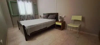 a bedroom with a bed and a table and a chair at Sal service green moradias residence with pool in Santa Maria
