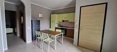 a small kitchen with a wooden table and chairs at Sal service green moradias residence with pool in Santa Maria