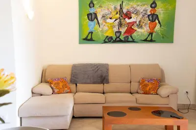 a living room with a couch and a painting on the wall at Aparthotel Tropical Bounty Beach L02 in Santa Maria