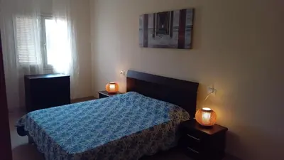 a bedroom with a bed with a blue comforter and a window at Brito Place in Santa Maria