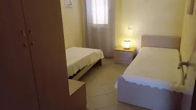 a bedroom with two beds and a lamp on a night stand at Brito Place in Santa Maria