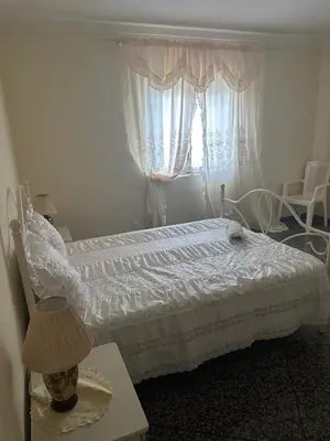a bedroom with a bed with a lamp and a window at Appartement avec Vue sur Mer à Praia, Wi-Fi, Navette Aéroport avec supplément in Praia