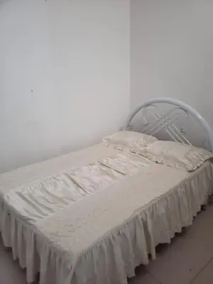 a bed with white sheets and a metal headboard at Appartement avec Vue sur Mer à Praia, Wi-Fi, Navette Aéroport avec supplément in Praia