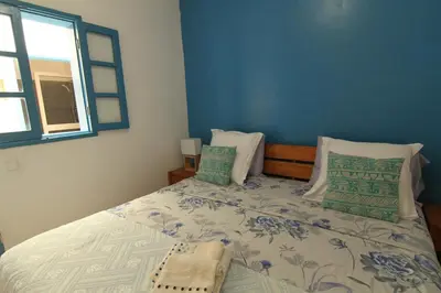 a bedroom with a bed with a blue wall at Casinha Azul Cidade Velha - Blue House Old Town in Cidade Velha