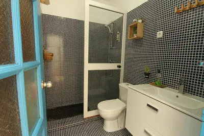 a bathroom with a toilet and a shower and a sink at Casinha Azul Cidade Velha - Blue House Old Town in Cidade Velha