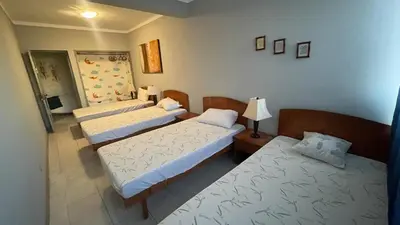 a room with three beds and a lamp at Girassol Tarrafal Apartment in Tarrafal
