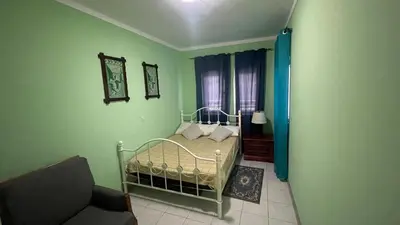 a green bedroom with a bed and a couch at Girassol Tarrafal Apartment in Tarrafal