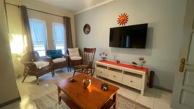 a living room with a tv on the wall at Girassol Tarrafal Apartment in Tarrafal
