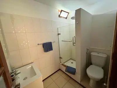 a bathroom with a toilet and a shower and a sink at Residencial Alto do Fortim in Mindelo
