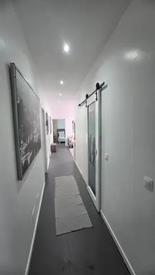 a hallway with white walls and a white rug at Family apartment with pool in Praia