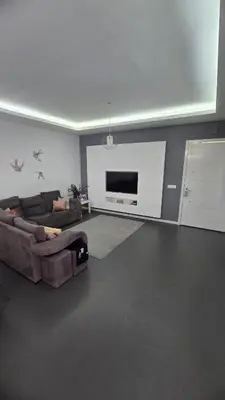 a living room with a couch and a flat screen tv at Family apartment with pool in Praia