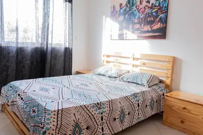 a bedroom with a bed with a quilt on it at Palmarejo, Apartamento T2 no Prédio Rosa Trás de pão quente in Praia