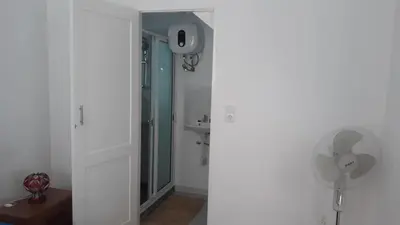 a bathroom with a shower and a fan in a room at FeliGrab in Mindelo