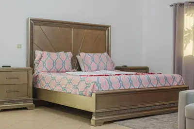 a bedroom with a large bed with a wooden headboard at Cidade Serena in Cidade Velha