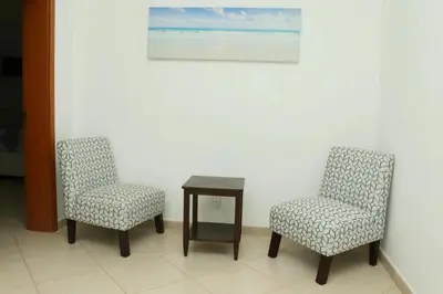 two chairs and a table in a room at Cidade Serena in Cidade Velha